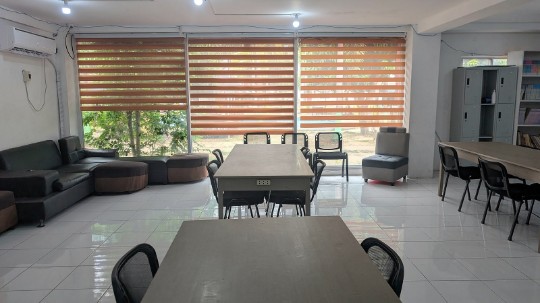 A bright classroom with sofas, tables and large windows