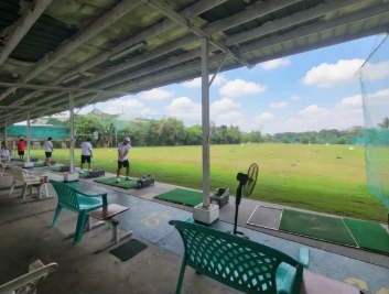 Tempat latihan golf dengan bilik pukul dan hamparan rumput luas