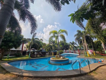 Kolam renang dengan tangga dan pegangan di bawah langit cerah