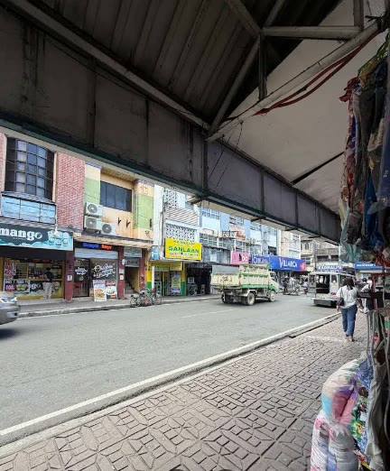 Jalan dengan deretan toko di bawah jalan layang