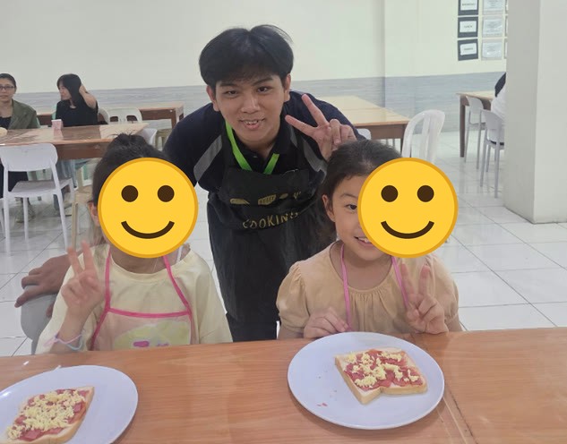 Dua anak bercelemek bersama guru memasak dan pizza roti panggang di atas piring