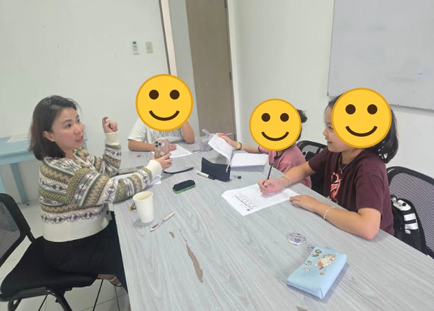 Seorang guru dan anak-anak mengelilingi meja di kelas kelompok
