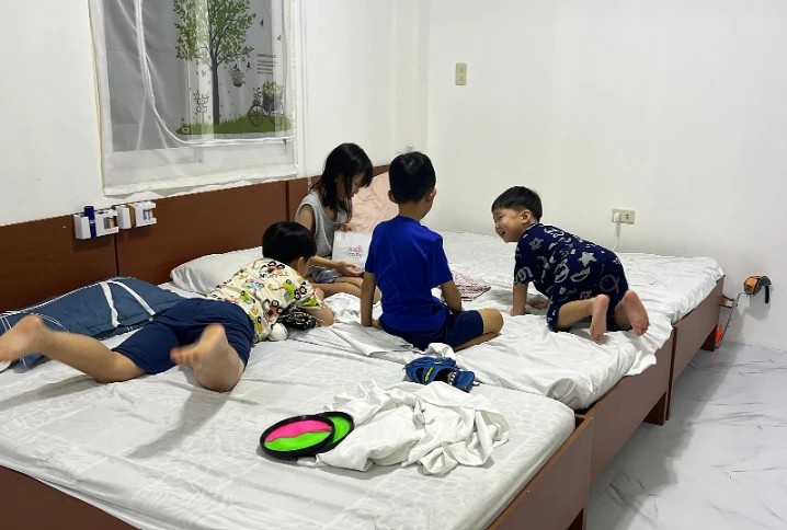 Children playing together on dormitory beds