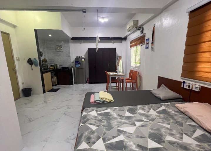 A family room with two wide beds and the kitchen area