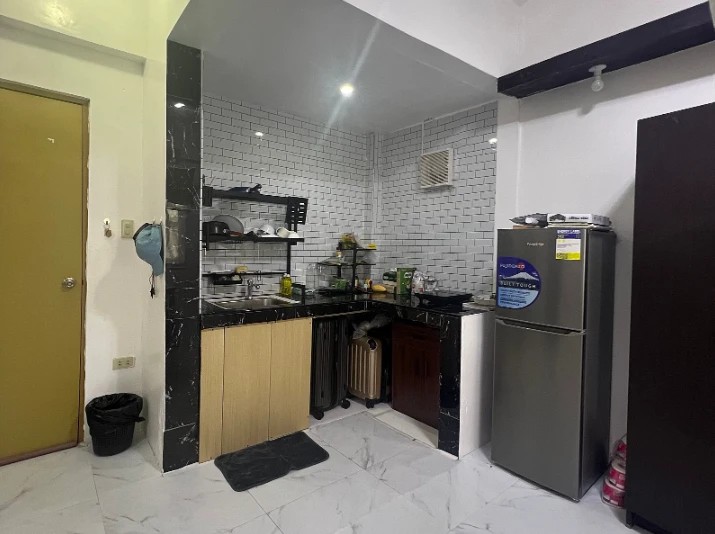 The kitchen of a family room with a sink and a fridge