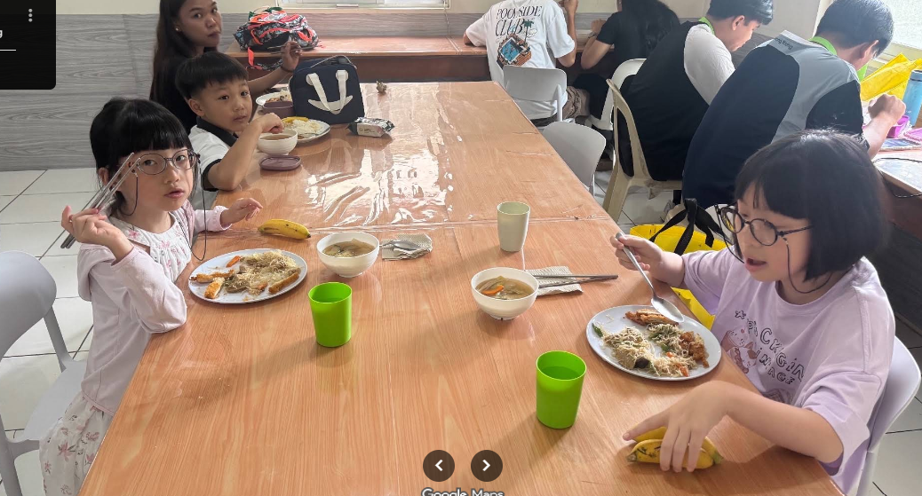 Okulun yemek salonunda birlikte yemek yiyen çocuklar