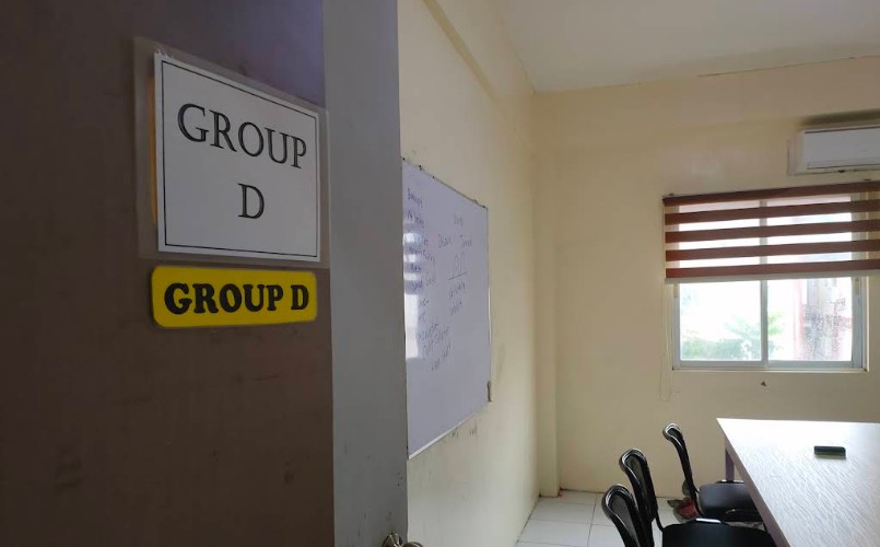 The door of the Group D classroom, with a whiteboard, a table and chairs inside