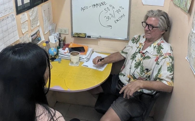 A teacher explaining at a whiteboard to a student in a one-on-one class