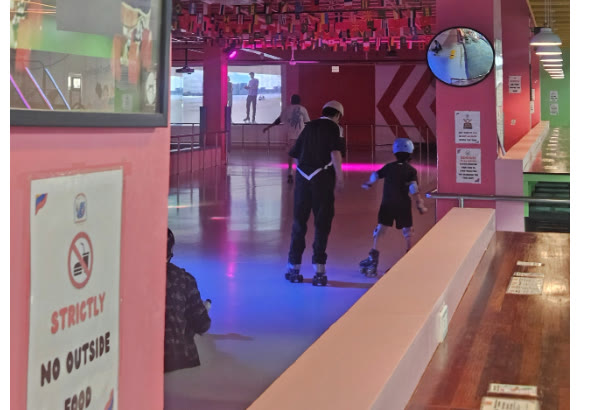 Seorang anak bermain sepatu roda didampingi pelatih