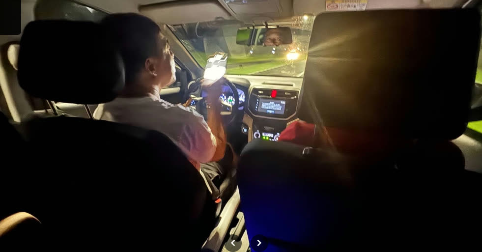 Sopir di kursi depan dalam perjalanan ke hotel pada malam hari